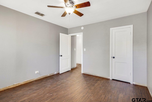 unfurnished bedroom with baseboards, dark wood-style flooring, visible vents, and a ceiling fan