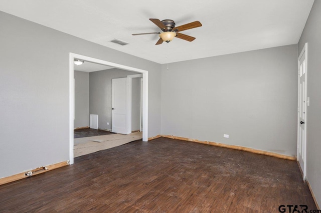 unfurnished room with baseboards, visible vents, ceiling fan, and dark wood-style flooring