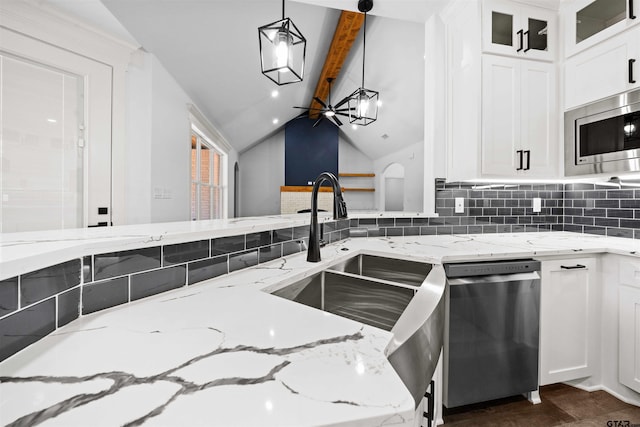 kitchen featuring appliances with stainless steel finishes, pendant lighting, lofted ceiling with beams, white cabinets, and decorative backsplash