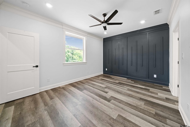 unfurnished bedroom featuring hardwood / wood-style floors, crown molding, and ceiling fan