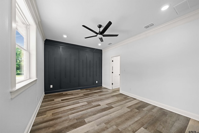 unfurnished bedroom featuring hardwood / wood-style flooring, ornamental molding, and ceiling fan