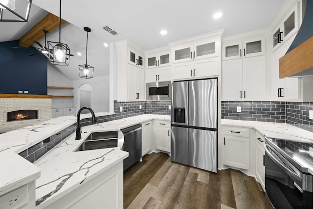 kitchen featuring sink, white cabinetry, hanging light fixtures, stainless steel appliances, and light stone countertops