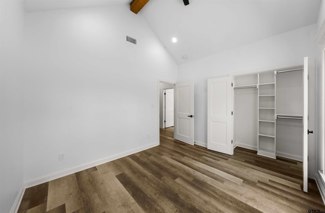 unfurnished bedroom featuring ceiling fan, high vaulted ceiling, dark hardwood / wood-style floors, a closet, and beamed ceiling