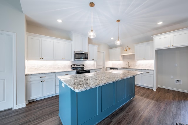 kitchen featuring hanging light fixtures, sink, appliances with stainless steel finishes, dark hardwood / wood-style flooring, and white cabinetry