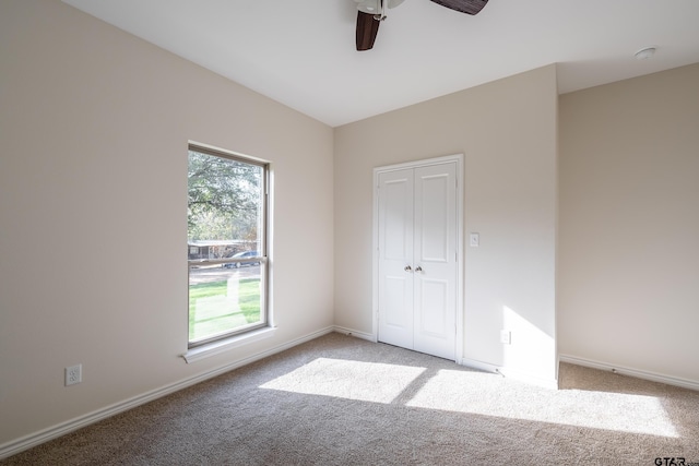 unfurnished bedroom featuring ceiling fan, a closet, and light carpet