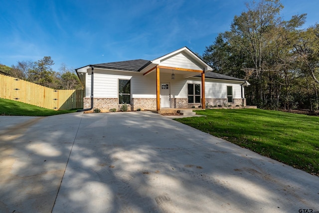 view of front of home with covered porch and a front lawn