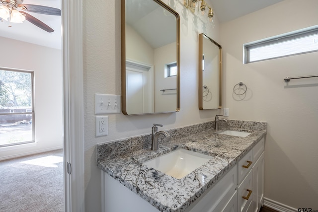 bathroom with vanity, a healthy amount of sunlight, and vaulted ceiling