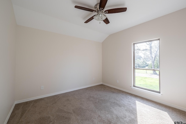 carpeted spare room featuring ceiling fan and vaulted ceiling