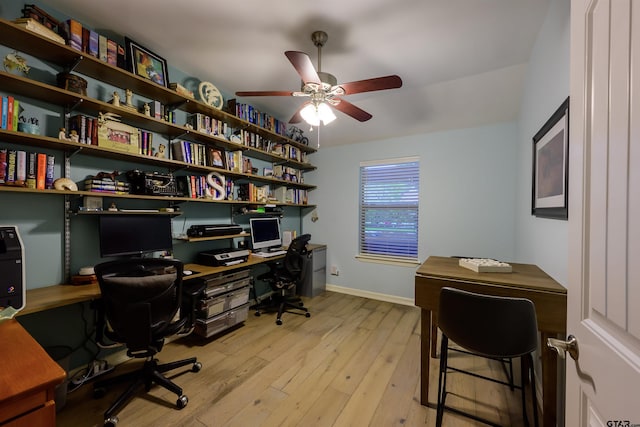 office area with baseboards, light wood-type flooring, and ceiling fan