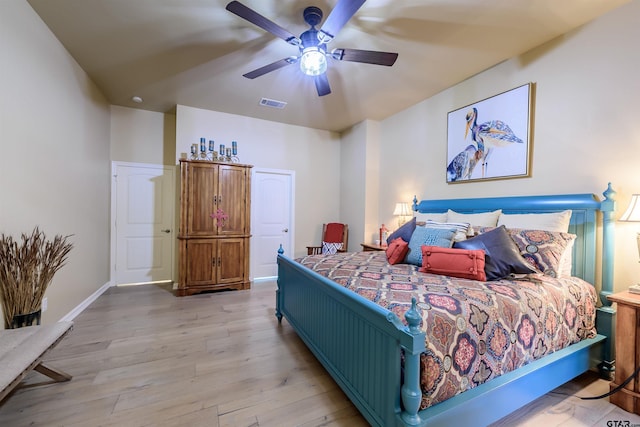 bedroom featuring baseboards, ceiling fan, visible vents, and light wood-style floors