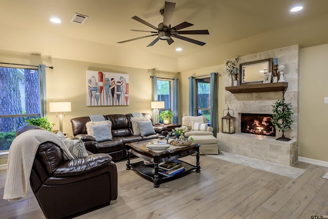 living room with a ceiling fan, a fireplace, visible vents, light wood-style floors, and recessed lighting