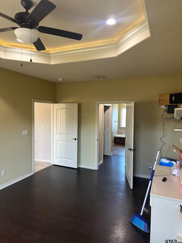 interior space with dark hardwood / wood-style flooring, crown molding, and a raised ceiling