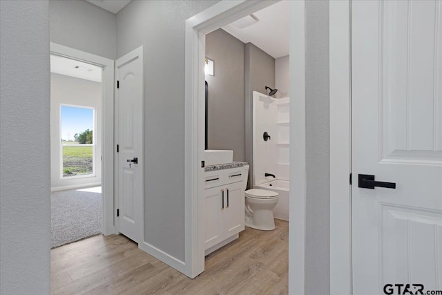 full bathroom featuring hardwood / wood-style flooring, vanity, toilet, and bathing tub / shower combination