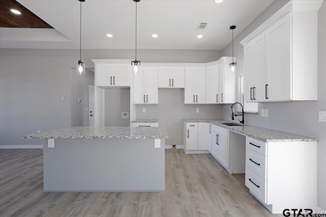 kitchen with white cabinets, a center island, and hanging light fixtures