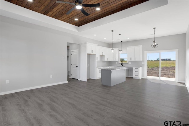 kitchen with white cabinetry, a center island, dark wood-type flooring, decorative light fixtures, and wood ceiling