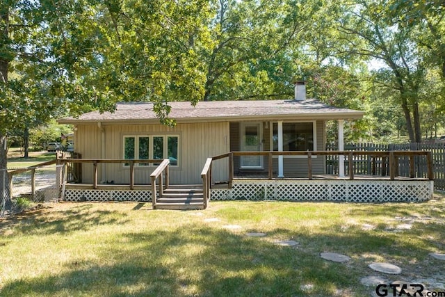 back of property featuring a deck and a yard