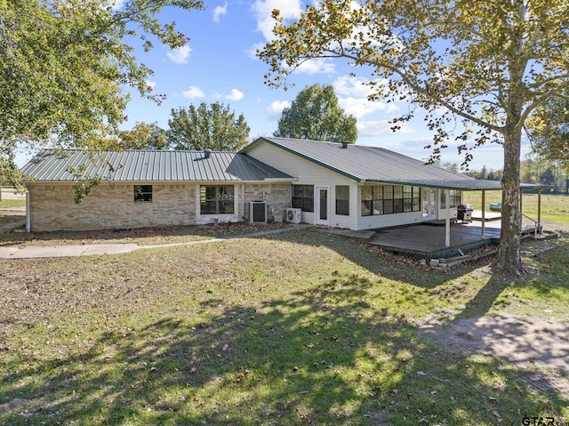 back of house with a lawn, a deck, and central AC