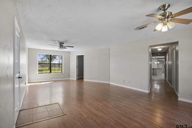 spare room featuring ceiling fan, dark hardwood / wood-style flooring, and a textured ceiling