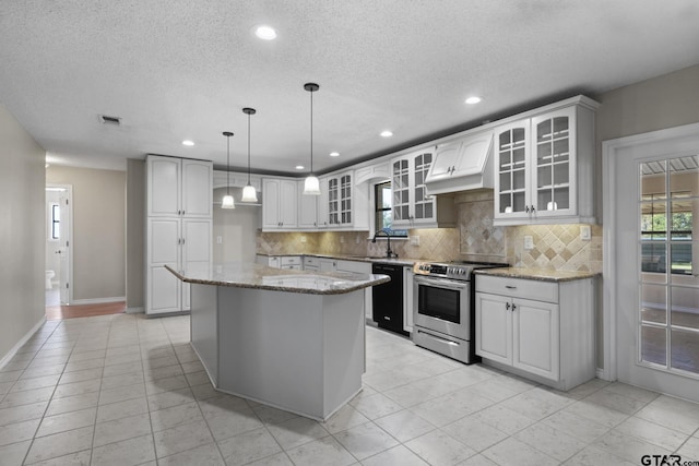 kitchen with light stone countertops, dishwasher, white cabinets, a center island, and stainless steel electric range