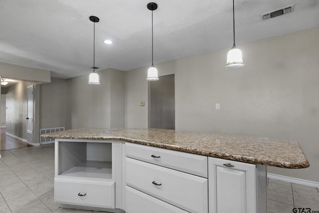 kitchen with white cabinets, a kitchen island, and hanging light fixtures