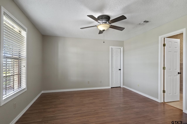 spare room featuring a textured ceiling, dark hardwood / wood-style flooring, and ceiling fan