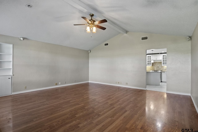 unfurnished living room with a textured ceiling, dark hardwood / wood-style flooring, lofted ceiling with beams, and ceiling fan