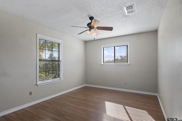 spare room featuring a textured ceiling, ceiling fan, and dark wood-type flooring