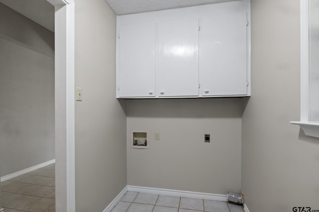 washroom with hookup for an electric dryer, cabinets, light tile patterned floors, and hookup for a washing machine