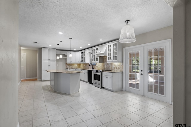 kitchen featuring french doors, a kitchen island, electric stove, white cabinets, and custom range hood