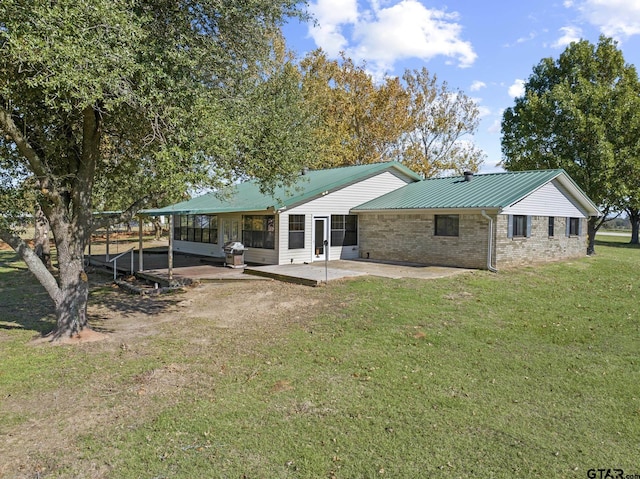 back of property featuring a lawn and a patio area