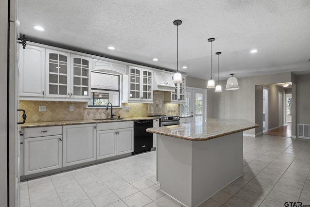 kitchen with white cabinets, black dishwasher, a kitchen island, and sink