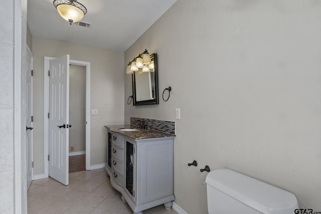 bathroom with tile patterned flooring, vanity, and toilet