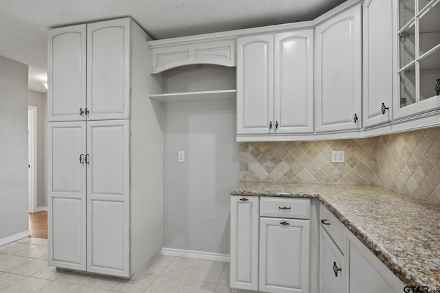 kitchen with decorative backsplash and white cabinetry