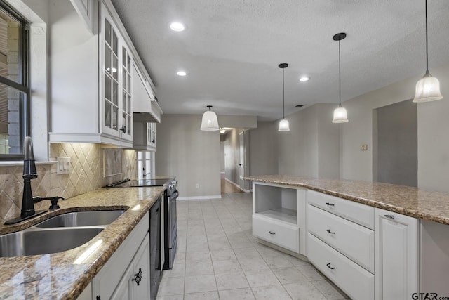 kitchen with pendant lighting, sink, decorative backsplash, light stone counters, and white cabinetry