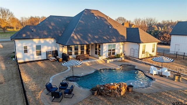 rear view of house featuring a fenced in pool, a chimney, a patio, and fence