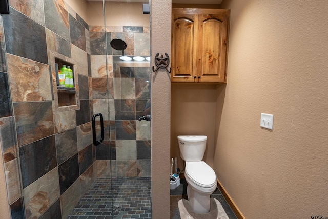 bathroom featuring toilet and a shower with shower door