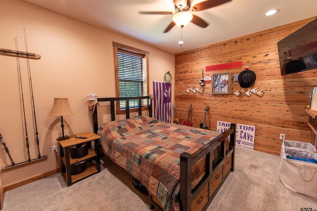 bedroom with light carpet, ceiling fan, and wood walls