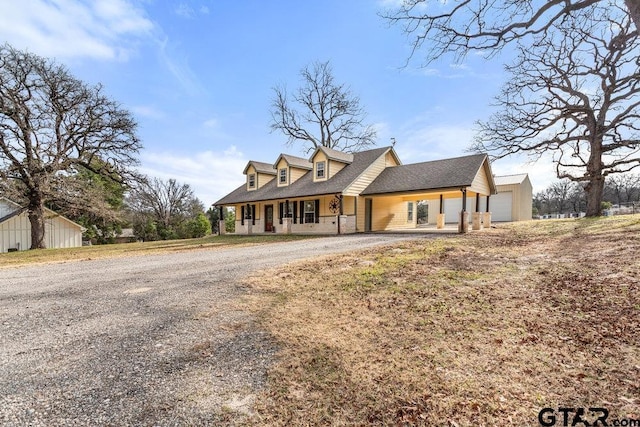 new england style home featuring a garage and covered porch