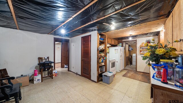 basement with washer / clothes dryer and white refrigerator