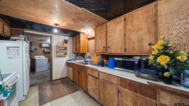 kitchen featuring wood walls, white appliances, and washer / dryer