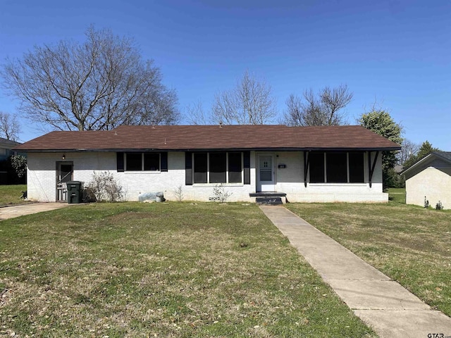 ranch-style house with a front lawn and brick siding