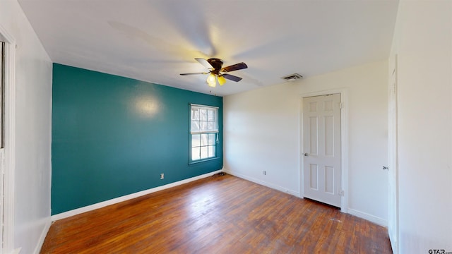 empty room with baseboards, visible vents, ceiling fan, and wood finished floors