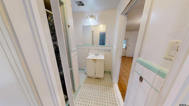 bathroom featuring tile walls and vanity