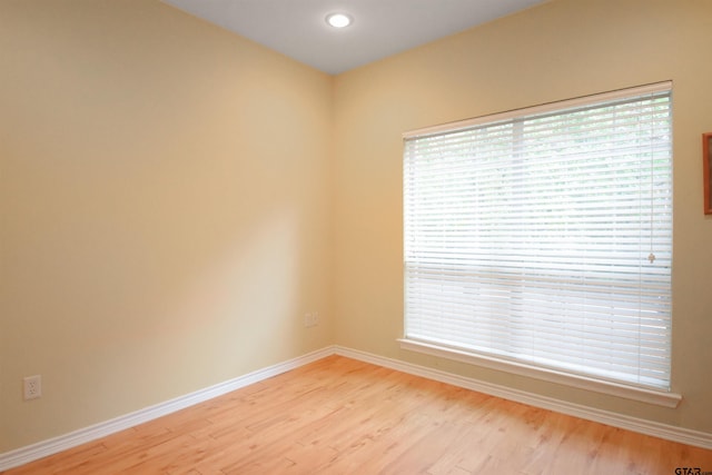 spare room with baseboards, light wood-style flooring, healthy amount of natural light, and recessed lighting