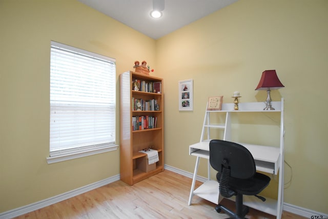 home office with wood finished floors, baseboards, and plenty of natural light