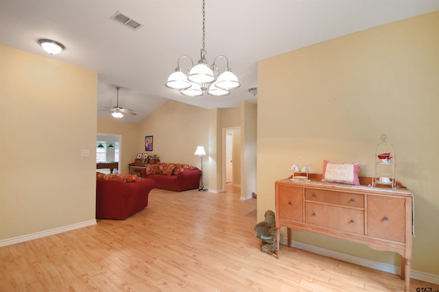 interior space featuring wood finished floors, ceiling fan, lofted ceiling, a chandelier, and baseboards