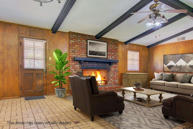 living room with wood walls, a fireplace, vaulted ceiling with beams, and ceiling fan