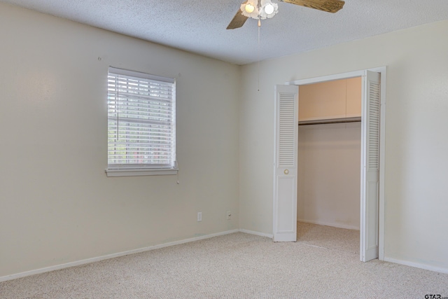 unfurnished bedroom with a closet, a textured ceiling, light carpet, and ceiling fan