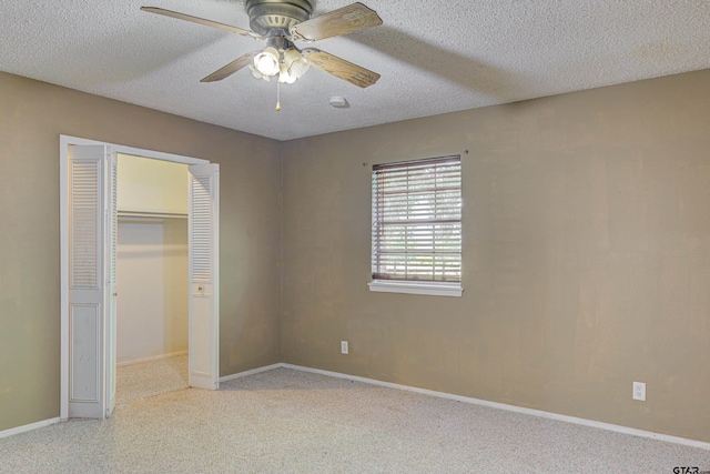 unfurnished bedroom featuring ceiling fan, a textured ceiling, and a closet