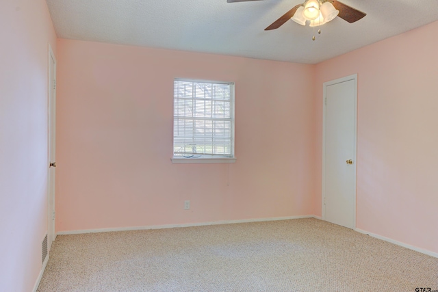 carpeted empty room featuring a textured ceiling and ceiling fan